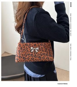 Detail of leopard print underarm bag with silver bow buckle on high-quality canvas fabric