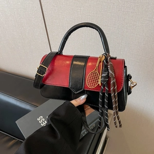 Sac à main carré bicolore rouge et noir avec pendentif raquette et pompons tissés