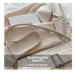 Detailed close-up of a cream white minimalist shoulder bag featuring a silver metal buckle