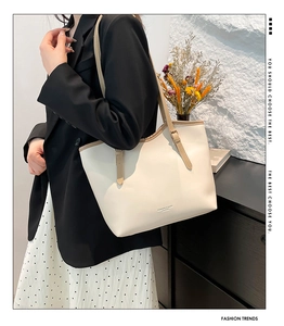 Detail of off-white faux leather tote bag with thin straps and metallic buckle detail