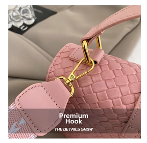 Macro shot of gold metal hardware and pink woven texture on a stylish crossbody bag
