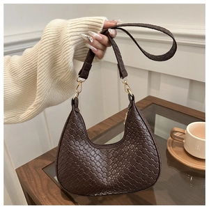 Detailed view of dark brown woven crescent bag with smooth zipper and gold hardware