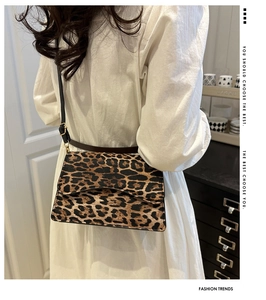 Borsa a spalla leopardata alla moda con tracolla regolabile indossata da una modella