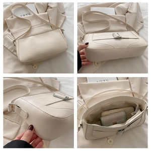 Detail view of beige leather shoulder bag with silver buckle and spacious interior