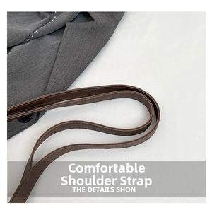 Detail of a brown leather shoulder strap with smooth edges and stitching for tote bags