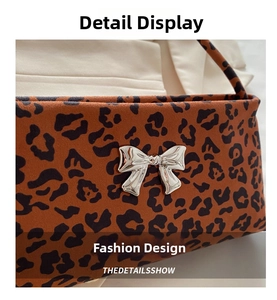 Close-up of leopard print suede shoulder bag with a metallic silver butterfly clasp detail