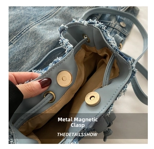 Dettaglio della chiusura magnetica e dei bordi in denim sfrangiato della borsa a secchiello