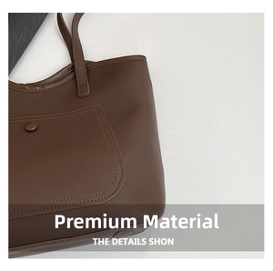 Close-up of brown faux leather tote bag with contrast stitching and button pocket detail