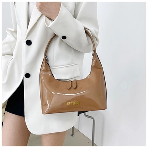 Detail of a brown patent leather hobo bag with gold EL'DORA logo and glossy finish