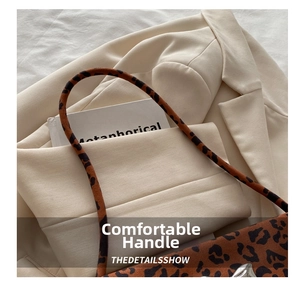 Close-up of leopard print shoulder bag with slim straps on a beige blazer