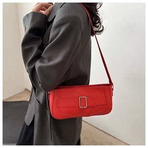 Fashionable red underarm bag with silver buckle worn with an oversized grey blazer