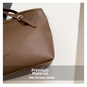Macro view of dark brown tote bag showing lychee grain texture and gold buckle detail