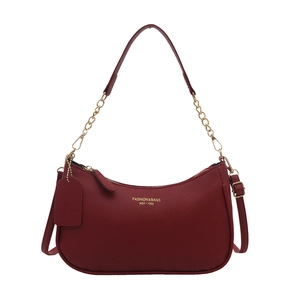 Minimalist burgundy crescent bag in grainy leather with gold chain strap on white background