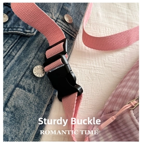 Detail of durable black plastic buckle on pink corduroy crossbody bag strap