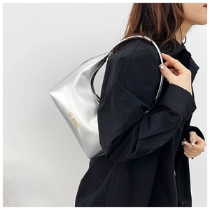 Detail of silver crescent shoulder bag with EL DORA logo and metallic handle ring