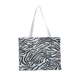 Minimalist zebra print tote bag with black and white stripes and sturdy woven handles
