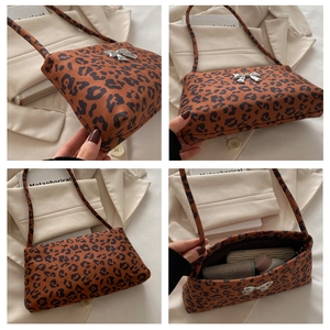 Detail of leopard print shoulder bag with silver bow accent and zipper closure
