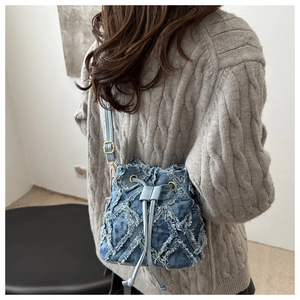 Dettaglio della borsa a secchiello in denim con trama trapuntata e coulisse regolabile