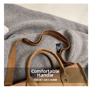 Close-up of brown canvas tote bag featuring thick handles and detailed inner brand label