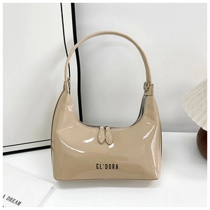 Close-up of beige patent leather handbag featuring EL'DORA lettering and dual zippers