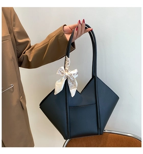 Close-up of black tote bag with V-shaped design and decorative geometric silk scarf