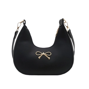 Minimalistische schwarze Halbmond-Schultertasche mit goldener Schleife auf weißem Grund