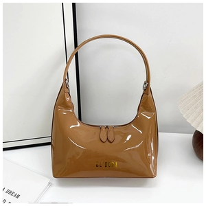 Close-up of caramel glossy patent leather bag with gold logo and dual zipper detail