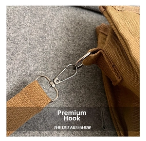 Detail of silver metal hook and durable khaki woven canvas strap on the shoulder bag