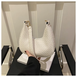 Detail of white woven crescent bag with gold buckle and crocodile pattern finish