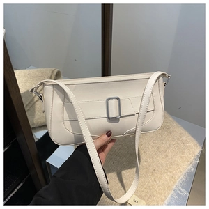 Detail of cream baguette bag featuring smooth texture and a silver rectangular metal buckle