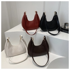 Group shot of moon-shaped woven shoulder bags in burgundy, black, white, and coffee brown