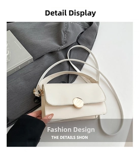 Close-up of a minimalist cream crossbody bag with a gold round buckle and slim strap