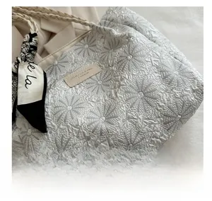 Close-up of floral jacquard tote bag with woven handles and decorative scarf detail