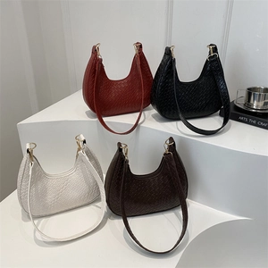 French woven crescent shoulder bags in red, black, white, and brown on display stands