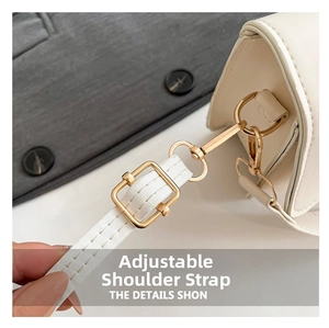 Detail of white leather shoulder bag featuring gold-tone hardware and adjustable strap