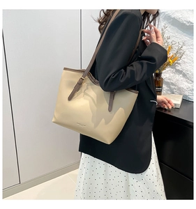 Commuter tote bag with adjustable brown straps and light beige leather texture shown on shoulder