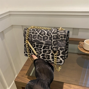 Sac à bandoulière léopard avec chaîne dorée dans un cadre intérieur minimaliste