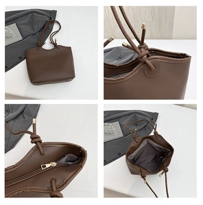 Detail view of coffee tote bag showing knotted straps, metal logo, and zipper closure