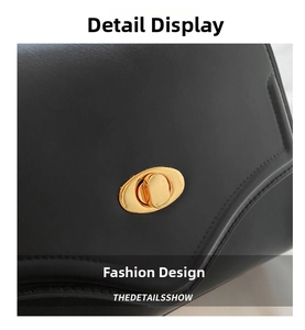 Close-up of elegant gold oval twist lock on premium black leather shoulder bag