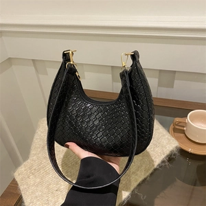 Minimalist black woven crescent hobo bag with gold hardware for elegant spring fashion