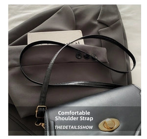 Detail of a black leather crossbody bag featuring an oval gold twist lock and fine stitching