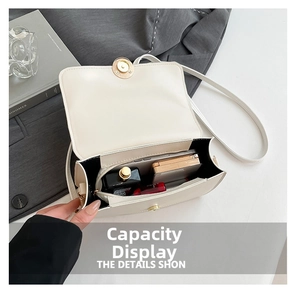 Interior view of small cream underarm bag showing space for phone and makeup