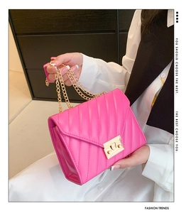Detail der rosaroten gesteppten Lederhandtasche mit Goldkette und Metallverschluss
