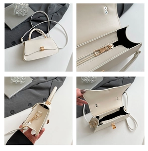 Detail showing inner zipper compartment and golden metal hardware of the cream handbag