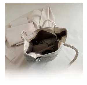 Detail of spacious tote bag with floral embossing and decorative scarf on a minimalist setup