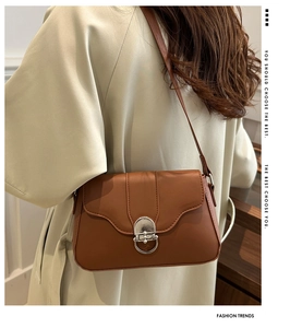 Detail of brown vintage flap bag with silver ring buckle on a beige trench coat