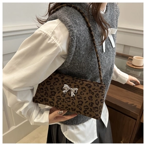 Close-up of leopard print shoulder bag with a silver metal butterfly bow accessory
