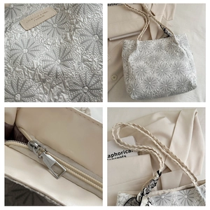 Macro detail of white floral jacquard fabric and woven handles on a tote bag