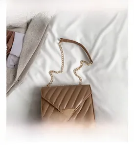 Detailansicht braune Stepptasche mit goldenem Metallverschluss und Kettenriemen