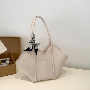 Chic beige tote bag with geometric wing design and decorative silk scarf detail